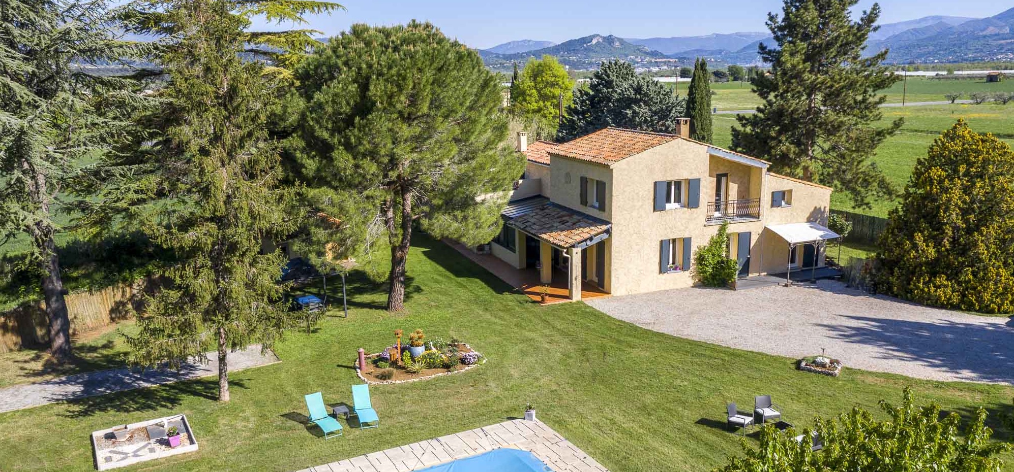 Photographie immobilière d'une villa avec piscine dans les Alpes de Haute Provence au printemps.